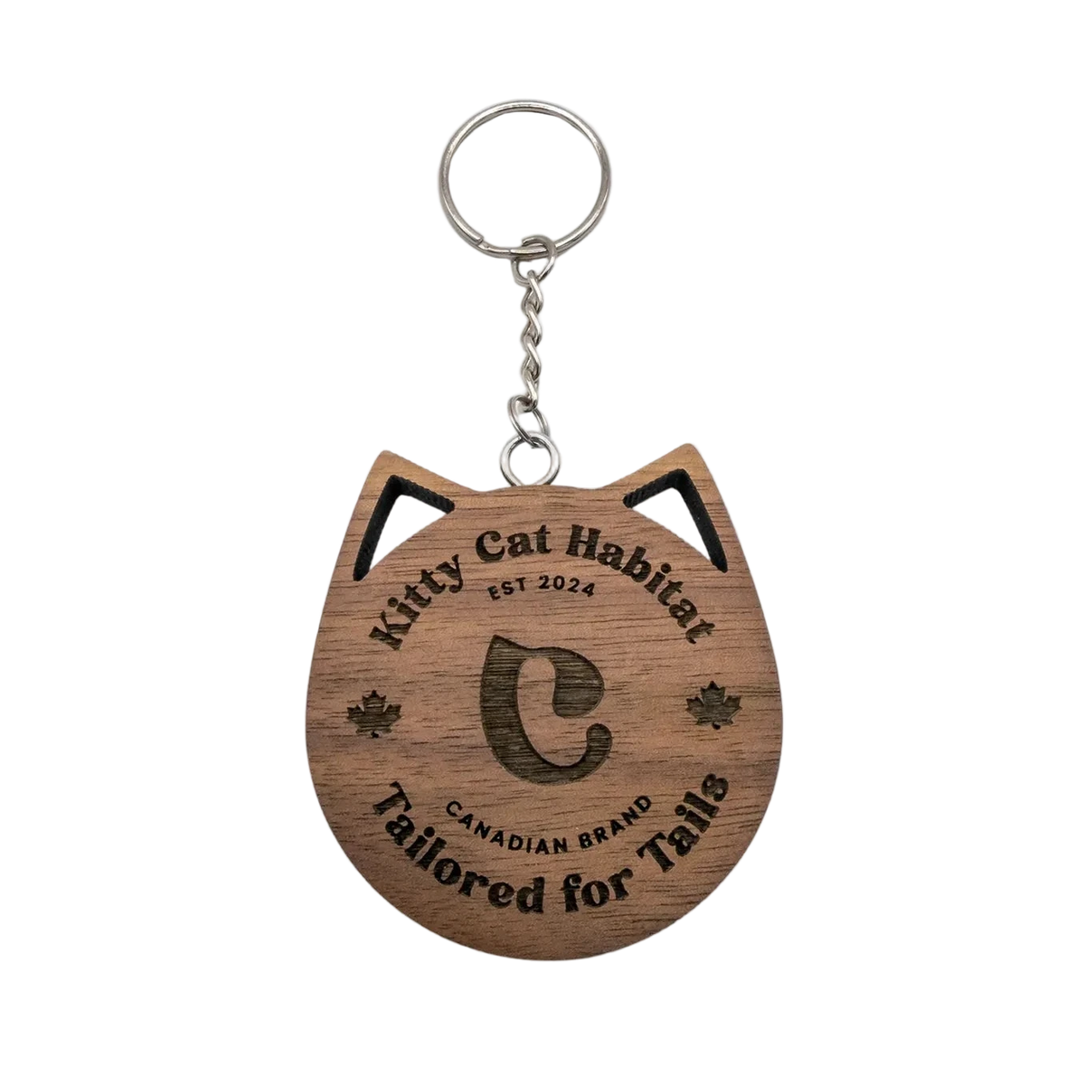 Walnut wooden cat head keychain with Kitty Cat Habitat logo engraving on a light background.