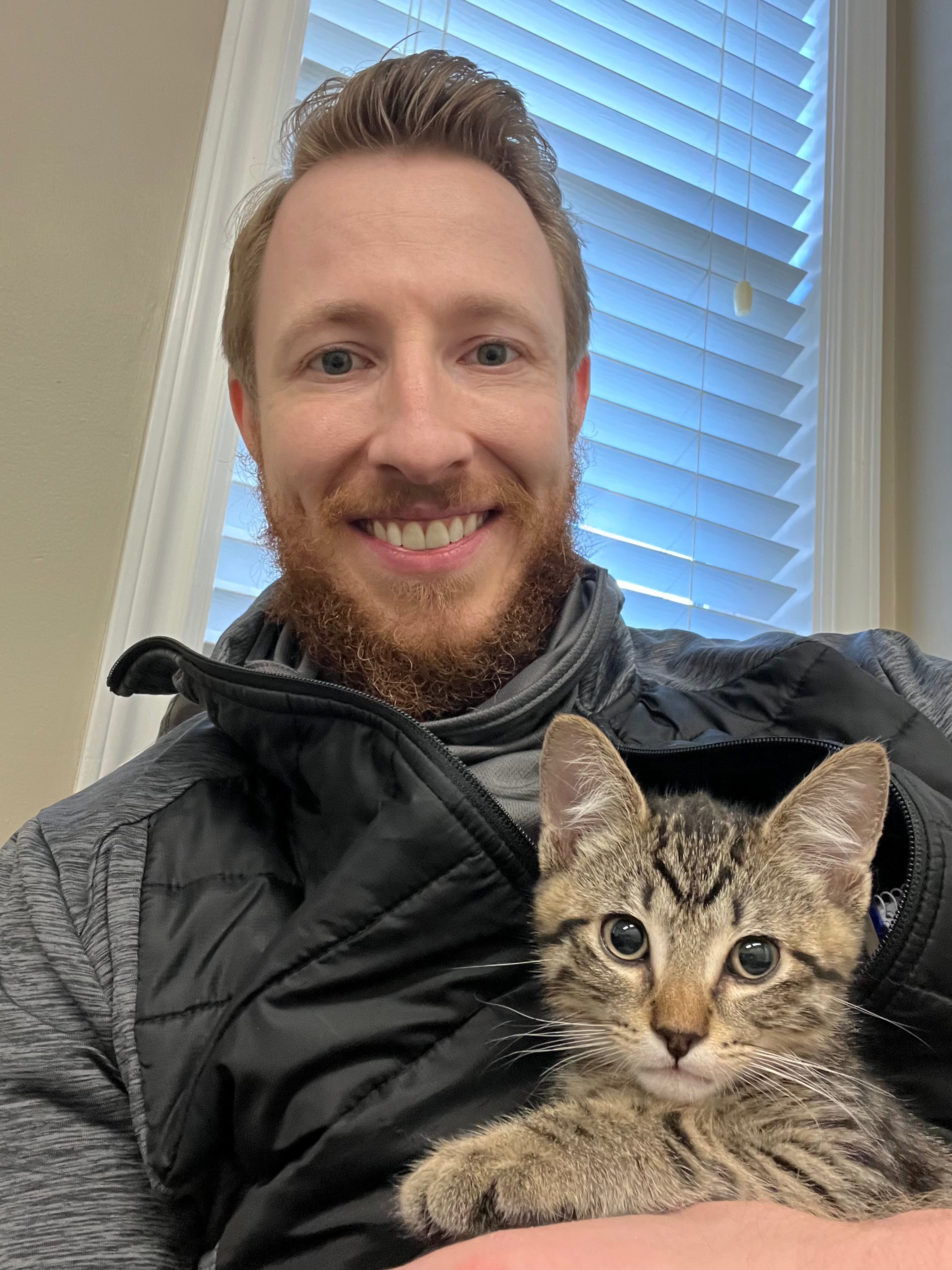 Sean Langwith, founder of Kitty Cat Habitat, holding Patrick as a kitten