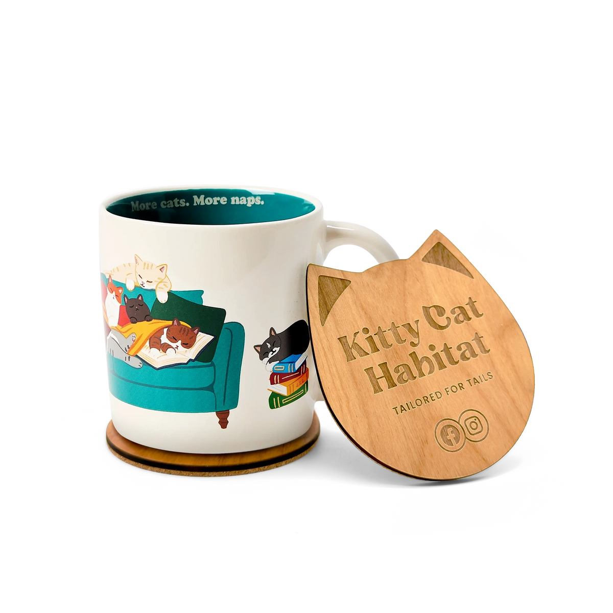 A ceramic mug with a colorful cat-themed illustration sits beside a wooden cat head shaped coaster. The lid is engraved with the text 'Kitty Cat Habitat' and 'TAILORED FOR TAILS'.