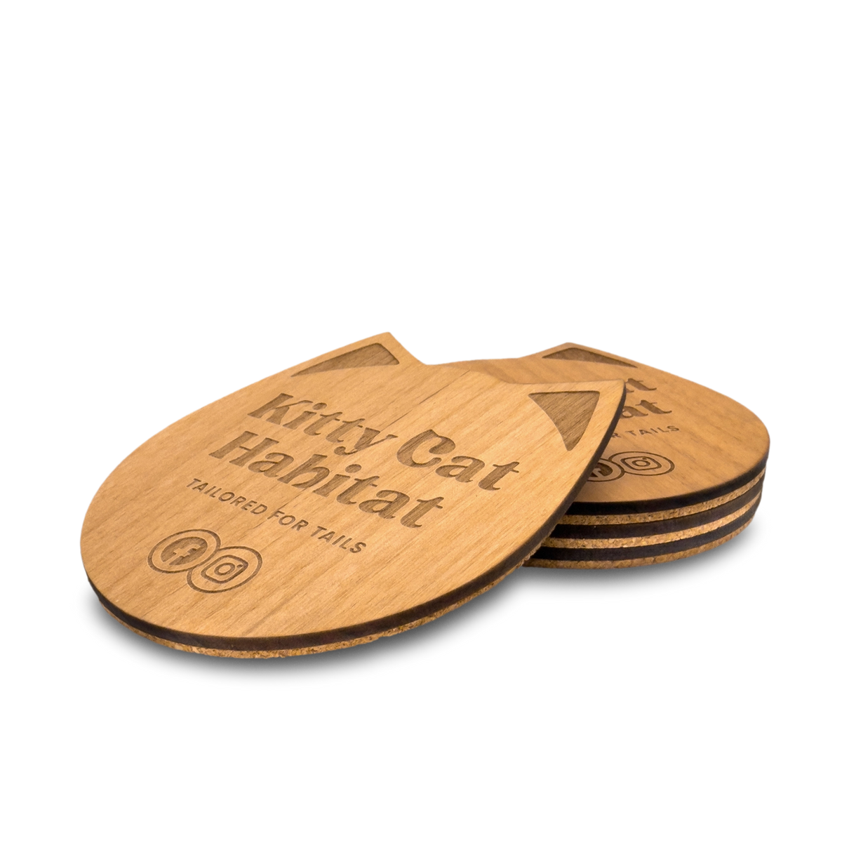 Small stack of wooden cat head drink coasters viewed from the side on a light background.
