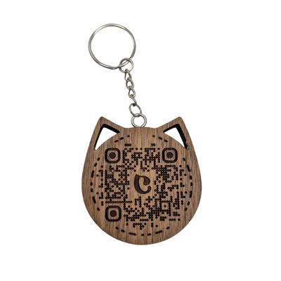 Walnut wooden cat head keychain showing an engraved QR code on a light background.